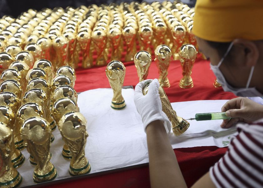 A worker paints models of the World Cup trophy, at a factory in Dongguan, Guangdong province, ahead of the 2014 World Cup in Brazil, June 10, 2014 Reuters