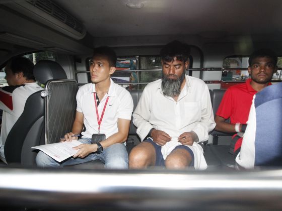 Ramzan Rizwan, 25, in red, and Rasheed Muhammad, 43 (second from right facing camera) arrive at Singapore State Courts June 14, 2014, to be charged for murder in case of legless body TODAY