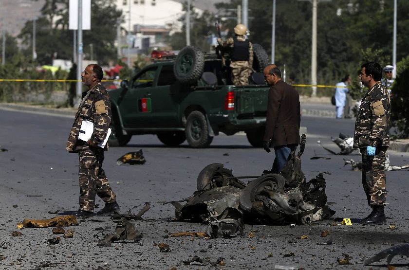 Officials investigate at the site of a bomb attack in Kabul June 21, 2014. A suicide bomber in western Kabul targeted top High Peace Council advisor Mohammad Massom Stanikzai June 20 Reuters