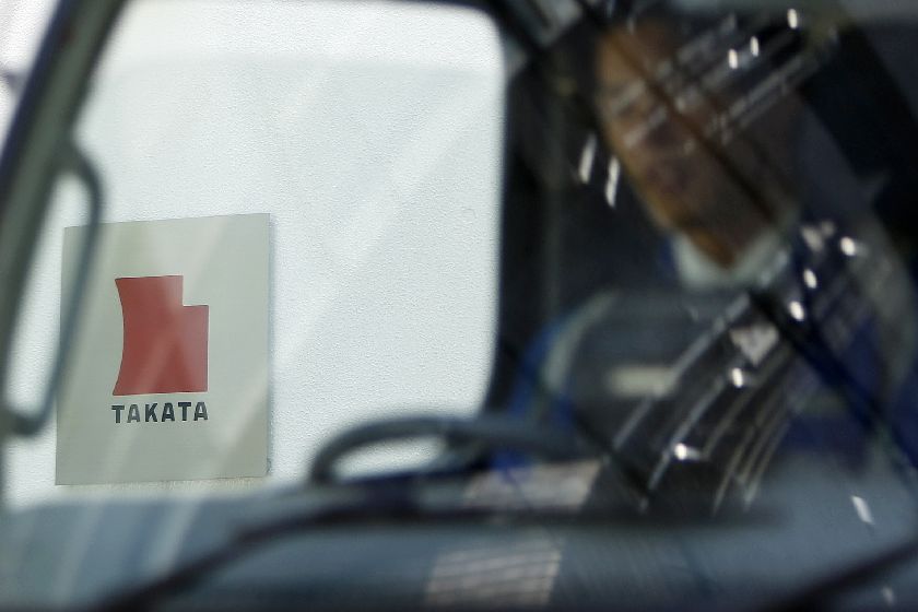 A logo of Takata Corp is seen through a car window outside the company's headquarter building in Tokyo in this April 12, 2013 file photo Reuters