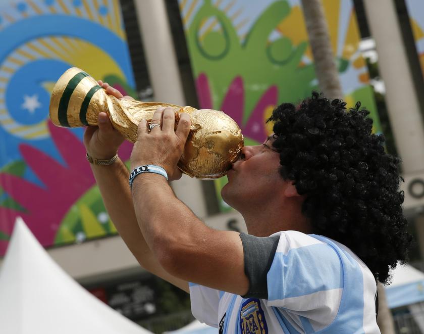 A street busker dressed up as Argentine soccer star Diego Maradona kisses a replica of the World Cup outside the Maracana stadium in Rio de Janeiro ahead of the 2014 World Cup, June 6, 2014. u00e2u20acu201d Reuters pic