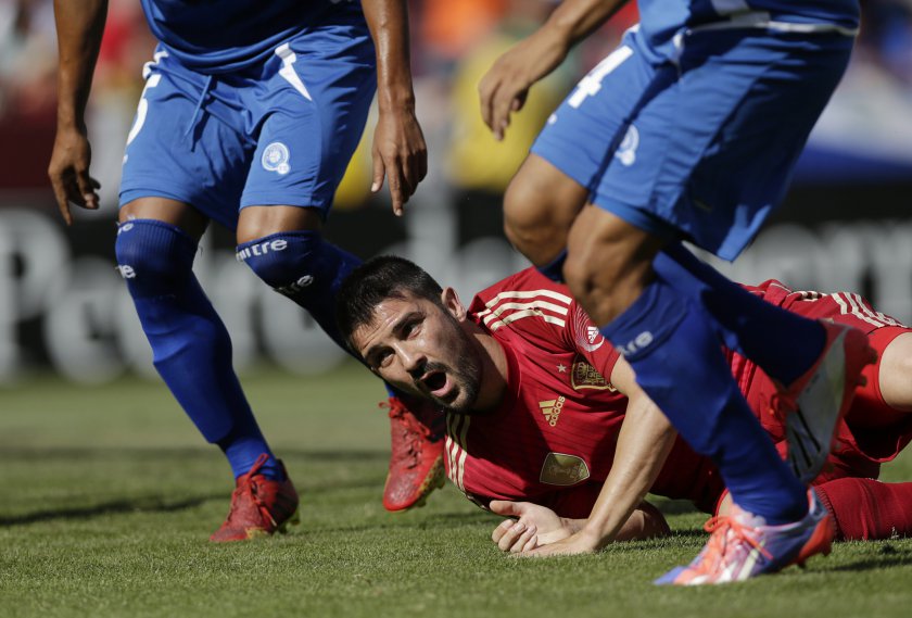 Spainu00e2u20acu2122s David Villa hits the pitch between two Salvador defenders during the second half of their friendly match in Landover, Maryland June 7, 2014. u00e2u20acu201d Reuters pic