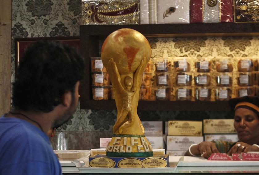 A customer looks at a replica of a one and a half feet tall and six kg FIFA World Cup trophy, made of sweets, at a bakery shop in Kolkata, ahead of the 2014 World Cup in Brazil, June 6, 2014. u00e2u20acu201d Reuters pic
