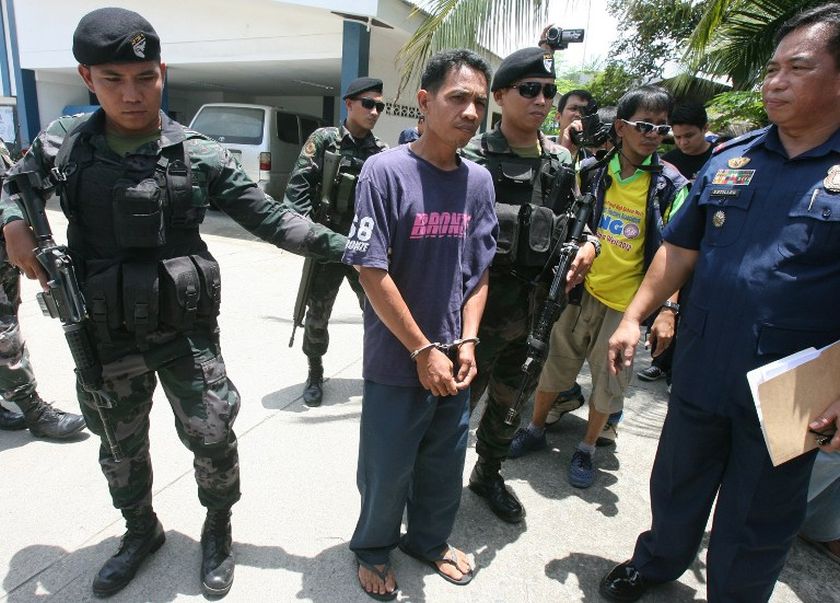 File picture shows police commandos escorting a suspected Al Qaeda-linked group Abu Sayyaf member (centre) in a police camp in Zamboanga City in the island of Mindanao. u00e2u20acu201d AFP pic
