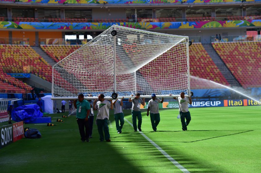 Volunteers carry a goal at the Amazonia Arena in Manaus on June 13, 2014, on the eve of the World Cup match between England and Italy. u00e2u20acu201d AFP pic