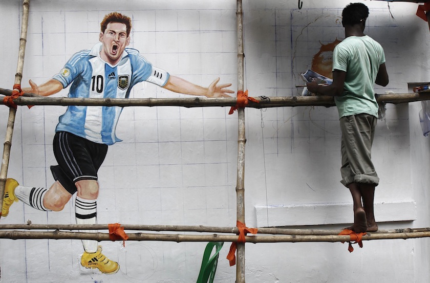 An artisan paints a roadside wall with pictures of 2014 World Cup participating players, in Kolkata June 9, 2014. u00e2u20acu201du00c2u00a0Reuters pic