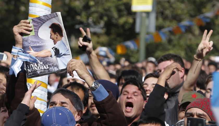 Argentina fans hold up a picture of player Lionel Messi as he watches a broadcast of the team's 2014 World Cup Group F match against Nigeria, in Buenos Aires June 25, 2014. u00e2u20acu201d Reuters pic