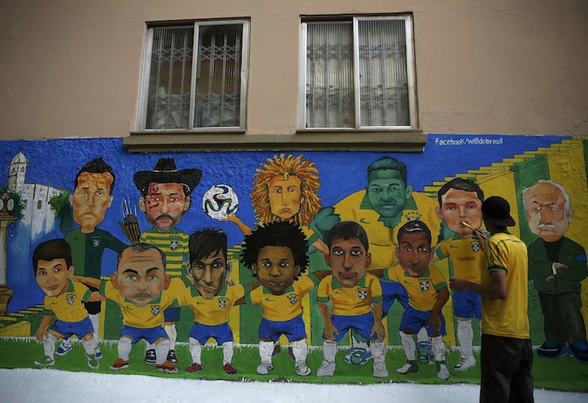 An artist paints a wall mural of the Brazilian national team and coach Luiz Felipe Scolari ahead of the 2014 World Cup, in Rio de Janeiro June 8, 2014. u00e2u20acu201d Reuters pic