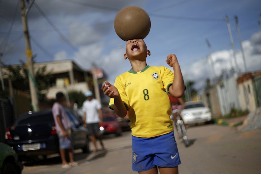 A boy heads a ball at the slum of Varjao on the outskirts of Brasilia, ahead of the 2014 World Cup Group A match between Brazil and Mexico, June 18, 2014.  u00e2u20acu201du00c2u00a0Reuters pic
