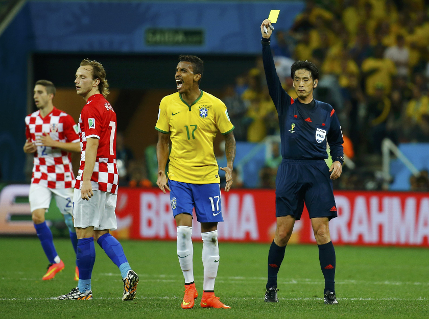 Brazil's Luiz Gustavo (2nd right) reacts after being issued with a yellow card by Referee Yuichi Nishimura of Japan (right) during their 2014 World Cup opening match against Croatia at the Corinthians arena in Sao Paulo June 12, 2014. u00e2u20acu201d Reuters pic