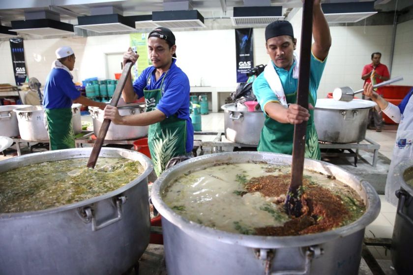 Helpers cooking a large pot of Bubur Lambuk at Masjid Jamek Kg Baru. u00e2u20acu201d Picture by Choo Choy May