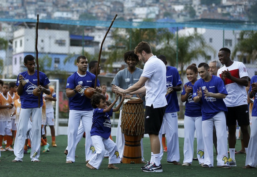 England player Adam Lallana shakes hands with a Brazilian boy as teammate Danny Welback (right) looks on during their visit to the sport complex at the Rocinha slum in Rio de Janeiro ahead the 2014 World Cup, June 9, 2014. u00e2u20acu201d Reuters pic