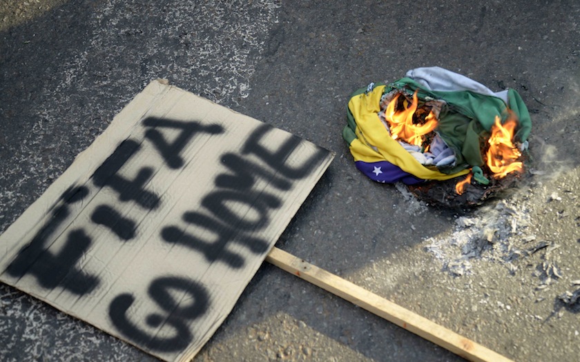A sign lies next to a burning Brazilian flag during a protest against the 2014 World Cup in Goiania June 3, 2014. u00e2u20acu201d Reuters pic