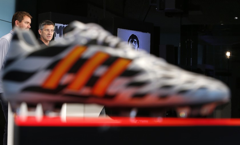 Adidas Chief Executive Officer Herbert Hainer (2nd left) is pictured behind a football shoe during a news conference in Herzogenaurach, near Nuremberg June 24, 2014. u00e2u20acu201d Reuters pic