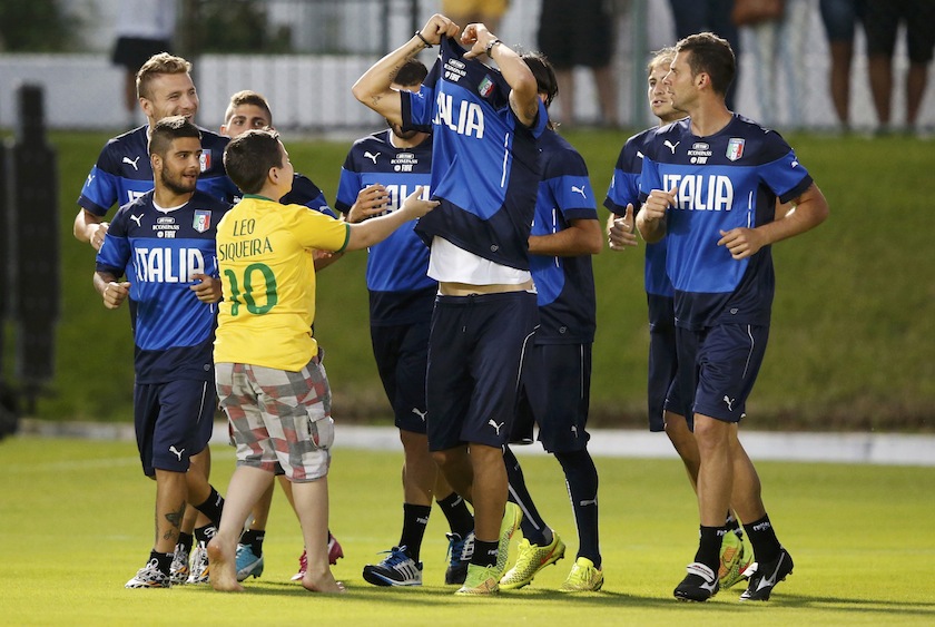Italy's national team player Leonardo Bonucci takes off his jersey to give to a boy who invaded the pitch during a training session at the Maria Lamas Farache-Frasqueirao stadium in Natal, June 22, 2014.u00c2u00a0u00e2u20acu201d Reuters pic