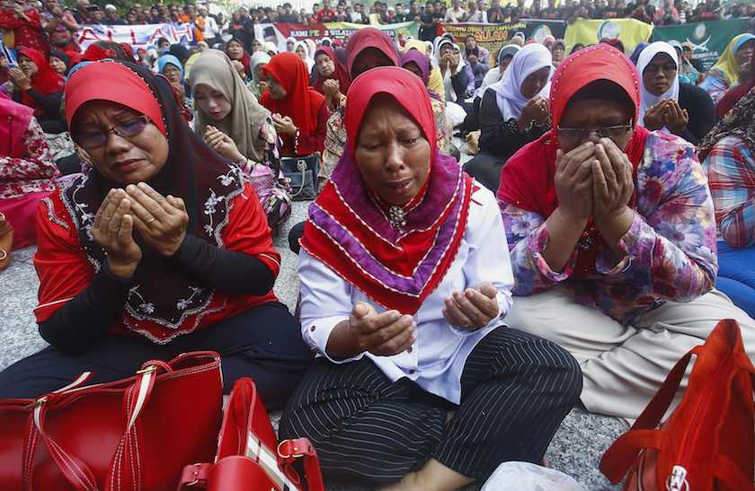 A Muslim woman cries as she recites a prayer outside the court in Putrajaya outside Kuala Lumpur June 23, 2014. u00e2u20acu201d Reuters pic