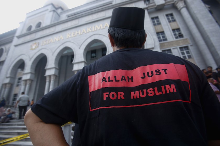 A Muslim man stands outside the court in Putrajaya outside Kuala Lumpur June 23, 2014. u00e2u20acu201d Reuters pic