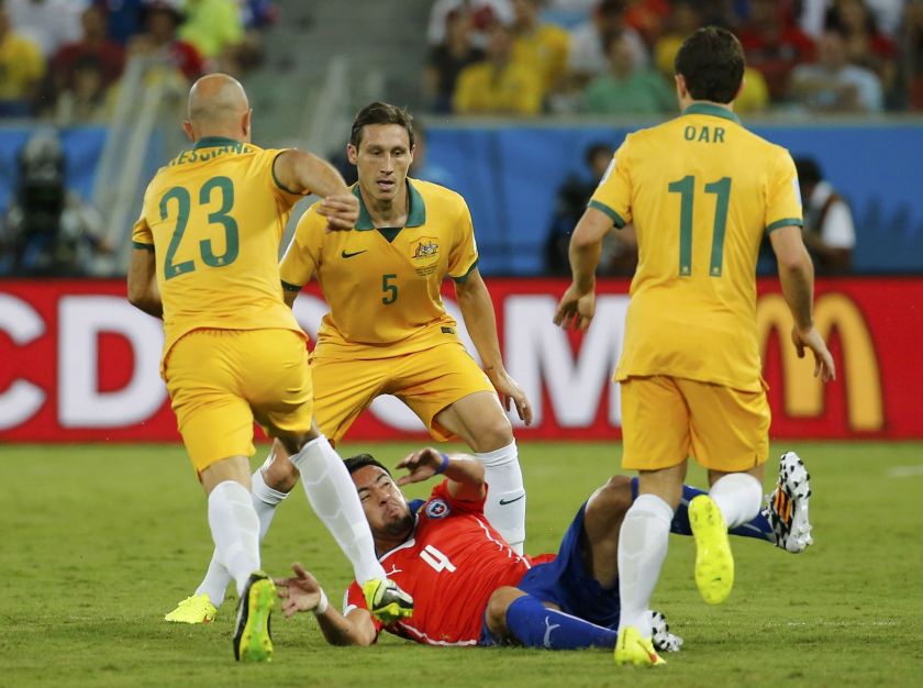 Chile's Mauricio Isla (bottom) falls under pressure from Australia's Mark Bresciano (left to right), Mark Milligan and Tommy Oar during their 2014 World Cup Group B match at the Pantanal arena in Cuiaba June 13, 2014. u00e2u20acu2022 Reuters pic  