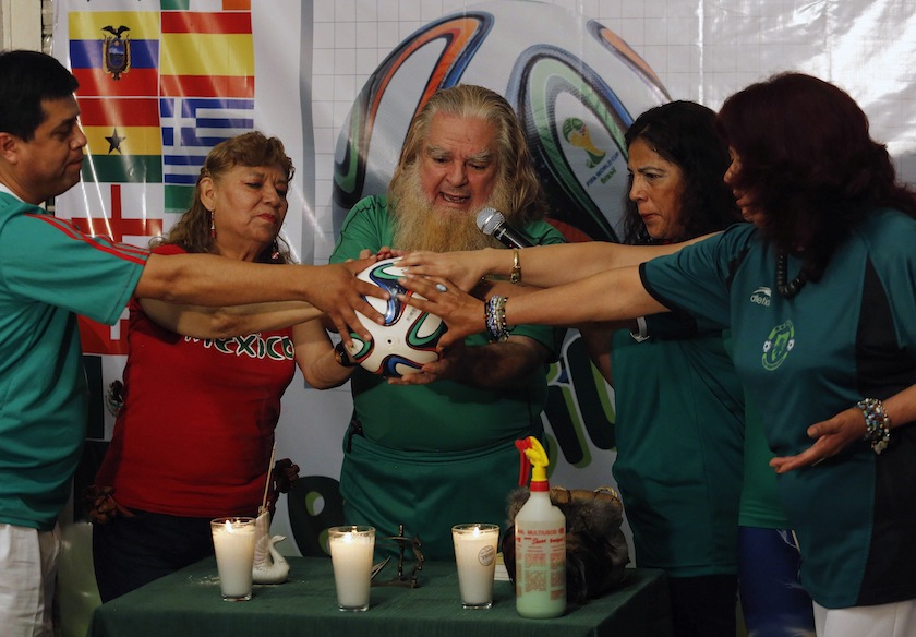 Professor Antonio Vazquez Alba 'Brujo Mayor' (centre), also known as Mexico's Grand Warlock, holds a  ball while presiding over a ceremony in Mexico City, to predict the country's performance in the World Cup, June 11, 2014.u00c2u00a0u00e2u20acu201d Reuters pic