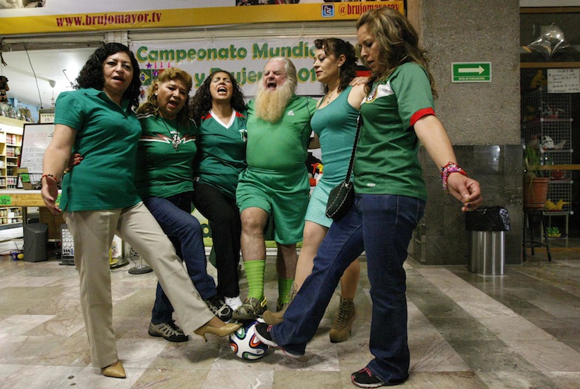 Professor Antonio Vazquez Alba 'Brujo Mayor' (centre), also known as Mexico's Grand Warlock, puts his leg on a soccer ball while presiding over a ceremony to predict the country's performance in the World Cup, in Mexico City June 22, 2014.u00c2u00a0u00e2u20acu201d Reuters pi