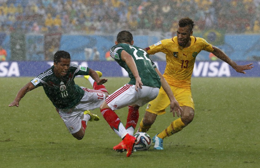 Mexico's Giovani Dos Santos (left) falls as teammate Mexico's Paul Aguilar fights for the ball with Cameroon's Eric-Maxim Choupo Moting during their 2014 World Cup Group A match in Natal June 13, 2014. u00e2u20acu201dReuters pic