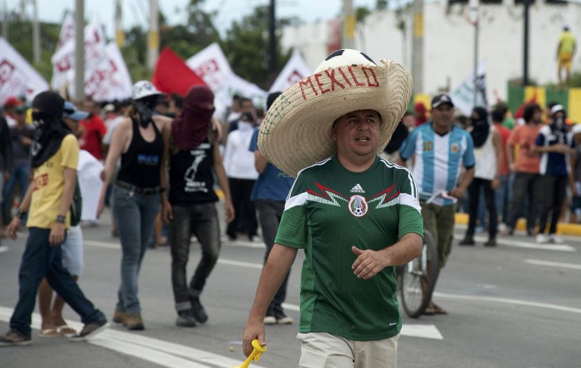 A Mexico football fan walks past a demonstration against the 2014 World Cup as he walks to the Castelao arena to watch Brazil and Mexico play in their Group A match, in Fortaleza June 17, 2014. u00e2u20acu2022 Reuters pic