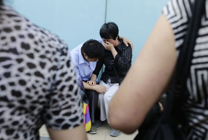 A woman, whose son was aboard the missing Malaysia Airlines flight MH370, cries with her husband after they failed to express their appeals to the airline outside its office in Beijing June 11, 2014. u00e2u20acu2022 Reuters pic