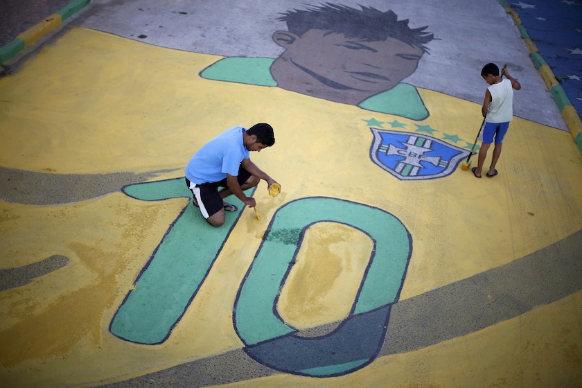 Boys touch up a painting of Brazilian player Neymar on a street decorated with references to the 2014 World Cup in the neighbourhood of Ceilandia in Brasilia, June 11, 2014. u00e2u20acu201d Reuters pic