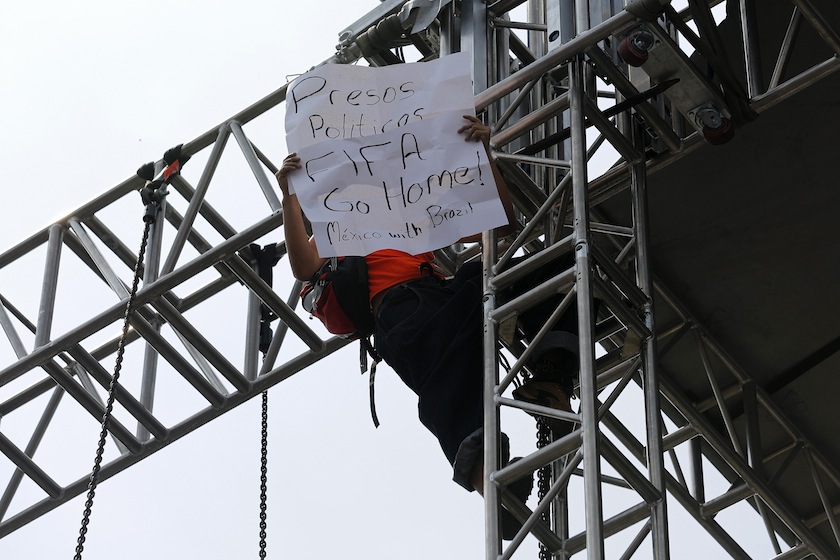 A demonstrator holds a sign as he protests from the top of a structure during a public screening of the 2014 World Cup opening match between Brazil and Croatia at Zocalo Square in downtown Mexico City June 12, 2014. u00e2u20acu201d Reuters pic