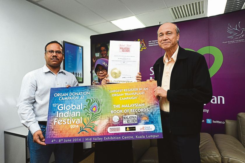 Ramesh (left) receives the Malaysia Book of Records certificate from Tan Sri Datuk Lee Lam Thye at the National Transplant Resource Centre yesterday. u00e2u20acu2022 Malay Mail pic 