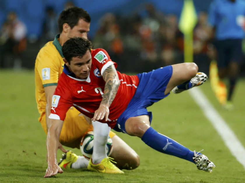 Chile's Eugenio Mena and Australia's Ryan McGowan (rear) fight for the ball during their 2014 World Cup Group B soccer match at the Pantanal arena in Cuiaba June 13, 2014. u00e2u20acu201d Reuters pic