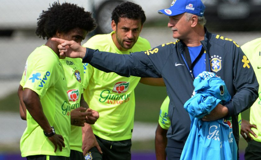 Brazilian coach Luiz Felipe Scolari (right) gives instructions to Willian (left) and Fred during a training session of the Brazilian national football team at the squad's training complex, in Teresopolis, 90 km from Rio de Janeiro, on May 29, 2014. u00e2u20acu201d AF