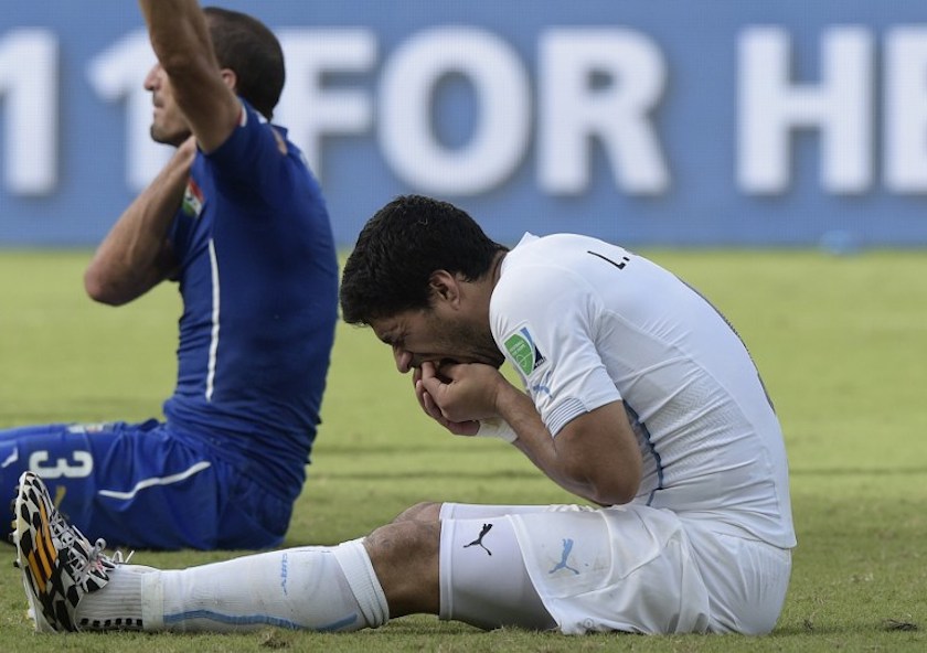 Uruguay forward Luis Suarez (right) puts his hand to his mouth after clashing with Italyu00e2u20acu2122s defender Giorgio Chiellini during a Group D football match between Italy and Uruguay at the Dunas Arena in Natal June 24, 2014. u00e2u20acu201d AFP pic