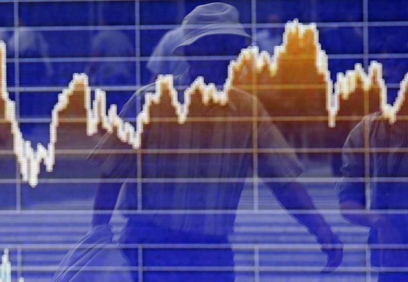 A pedestrian is reflected on an electronic board showing the graph of the recent fluctuations of the Tokyo Stock Exchange Stock Price Index (TOPIX), outside a brokerage in Tokyo June 2, 2014. u00e2u20acu201d Reuters pic