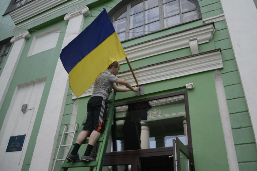 A man installs a Ukrainain flag outside a polling station in the vilage of Dobropillya in the Donetsk region of Ukraine, May 25, 2014. u00e2u20acu201d Reuters pic