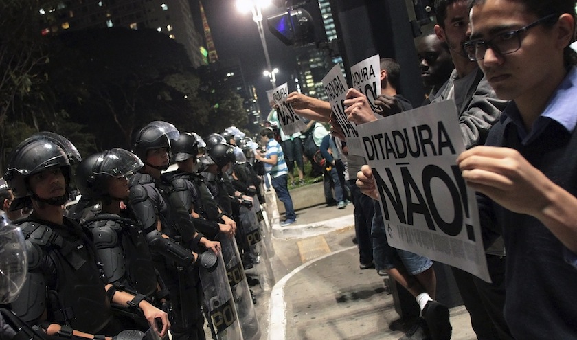 Demonstrators hold signs that read 'No dictatorship' in front of a line of riot police during a protest against the 2014 World Cup in Sao Paulo June 26, 2014. u00e2u20acu201du00c2u00a0Reuters pic