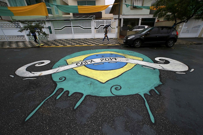 A woman passes a World Cup graffiti painted on the ground at a street near Urbano Caldeira stadium in Santos city, June 11, 2014.u00c2u00a0u00e2u20acu201du00c2u00a0Reuters pic