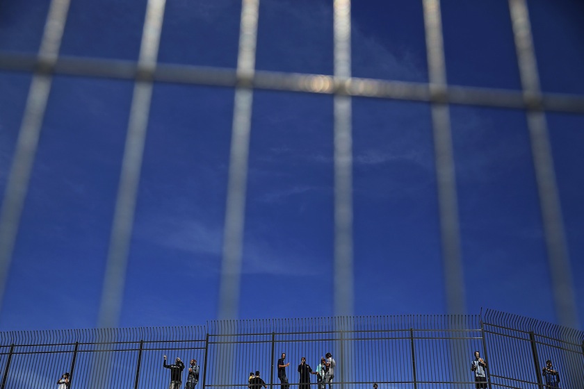 People look from behind fences as workers prepare the Corinthians arena in Sao Paulo June 7, 2014. u00e2u20acu201d Reuters pic