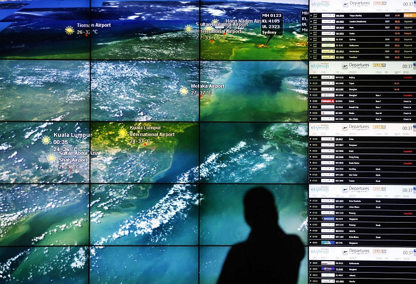 A man stands in front of a display showing plane locations around Malaysia at Kuala Lumpur International Airport in Sepang July 18, 2014. u00e2u20acu201d Reuters pic