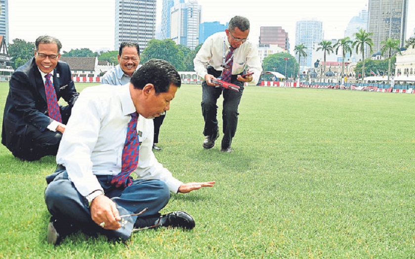 Ahmad Phesal sits on the newly sodded grass at Dataran Merdeka. u00e2u20acu201d Picture by Sarah Musfirah Putri