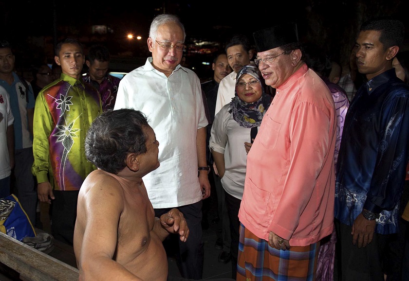 (From left) Prime Minister Datuk Seri Najib Tun Razak; Women, Family and Community Development Minister Datuk Rohani Abdul Karim and Federal Territories Minister Datuk Seri Tengku Adnan Tengku Mansor speak to a homeless man near the Kotaraya area in Kuala