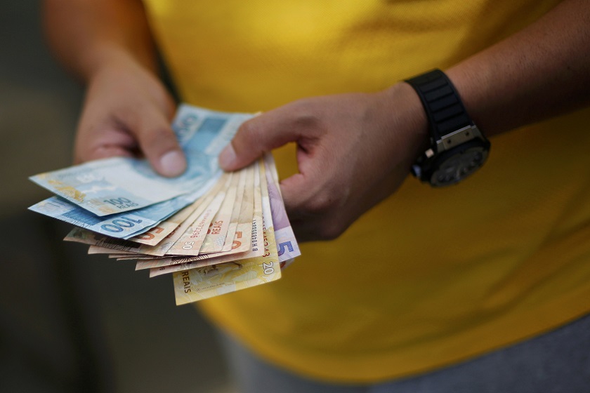 A man counts betting money while watching the round of 16 soccer match for the 2014 World Cup between Brazil and Chile, during a gathering in a home in the upper class neighborhood of Lago Sul in Brasilia, June 28, 2014 . u00e2u20acu201d Reuters pic