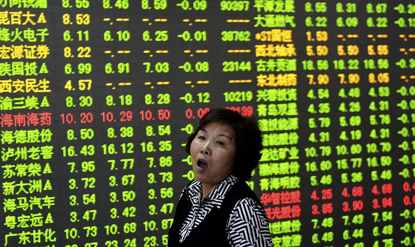 An investor yawns in front of an electronic board showing stock information at a brokerage house in Hangzhou, Zhejiang province June 19, 2014. u00e2u20acu201d Reuters pic