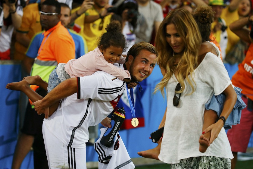 Germany's Mario Goetze and his girlfriend Kathrin Brommel carry the twin daughters of teammate Jerome Boateng, Soley and Lamia, at the end of during their 2014 World Cup final against Argentina at the Maracana stadium in Rio de Janeiro July 14, 2014.u00c2u00a0u00e2u20acu201d