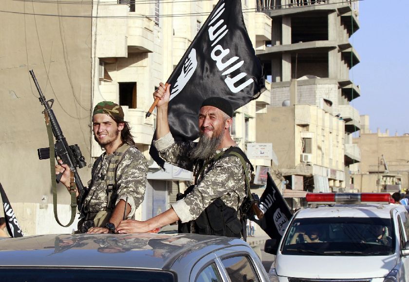 Militant Islamist fighters wave flags as they take part in a military parade along the streets of Syria's northern Raqqa province June 30, 2014, to celebrate their declaration of an Islamic ,caliphate, Reuters