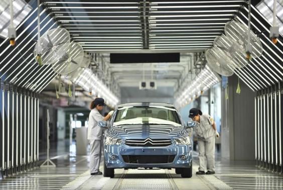 Employees work at the third factory of Dongfeng Peugeot Citroen Automobile company, after its inauguration ceremony, in Wuhan, July 2, 2013 Reuters