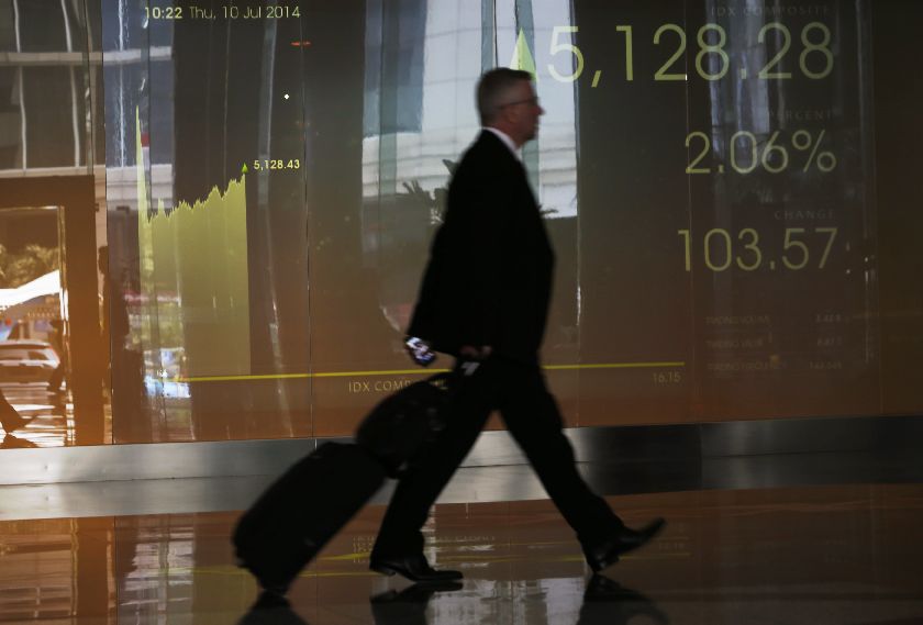 A man walks in front of the Indonesia Stock Exchange screen in Jakarta, July 10, 2014. Rose more than 2 per cent to a one-year high on expectations Joko ,Jokowi, Widodo will be the next president