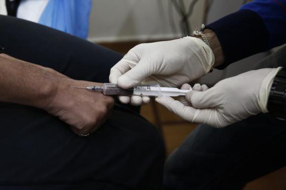 A drug user gives blood sample for a HIV test inside a clinic in Athens November 25, 2013. Reuters