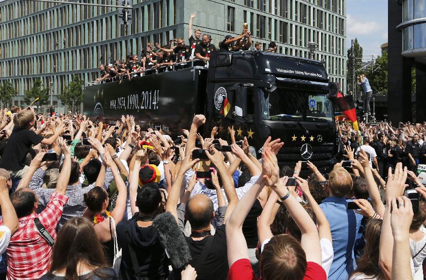 Germany's national football team players wave from an open-top bus during a celebration parade in Berlin July 15, 2014 Reuters