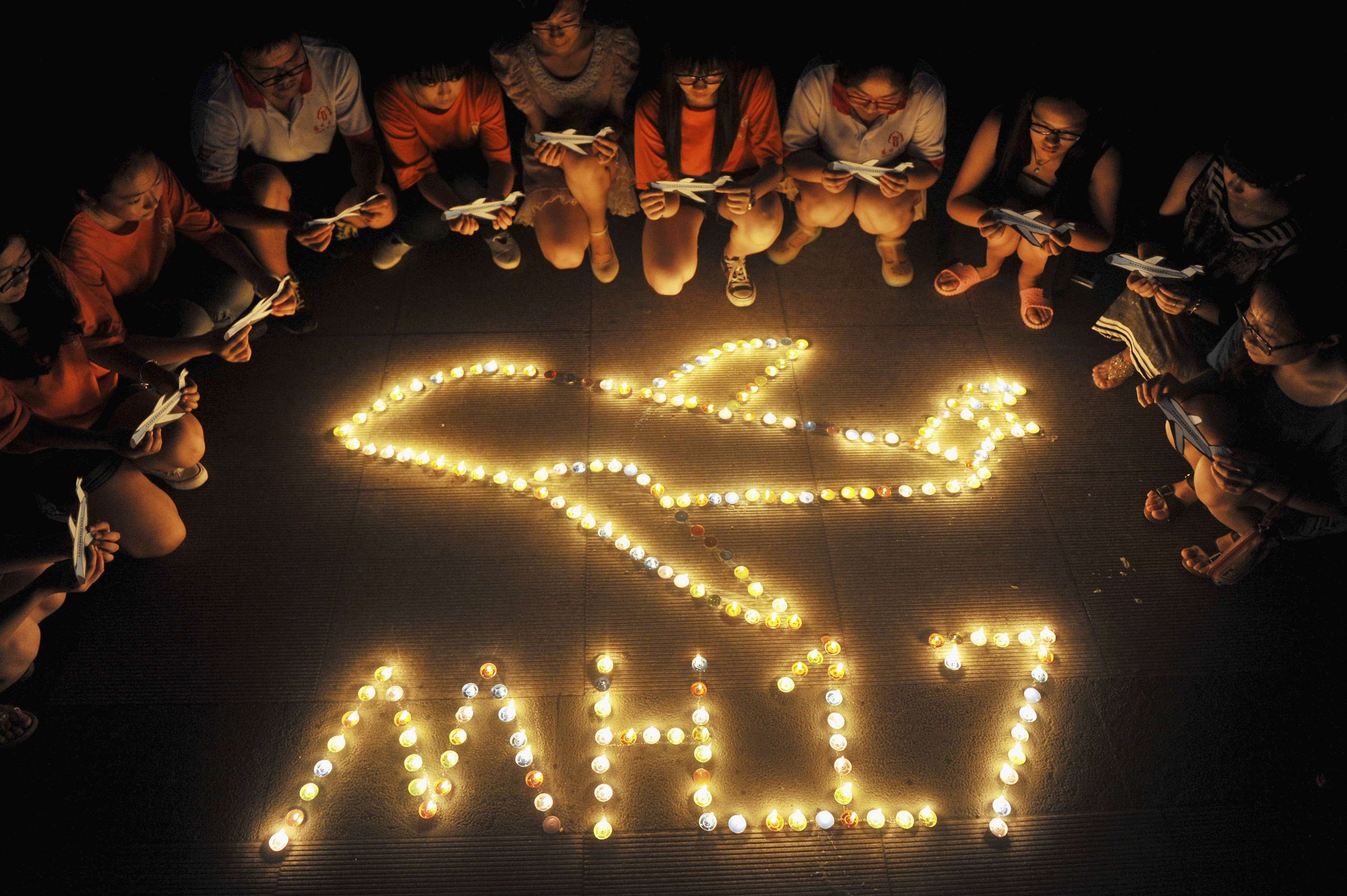 College students gather around candles forming the shape of an airplane, during a candlelight vigil for victims of the downed Malaysia Airlines Flight MH17, at a university in Yangzhou, Jiangsu province July 20, 2014. u00e2u20acu2022 Reuters pic